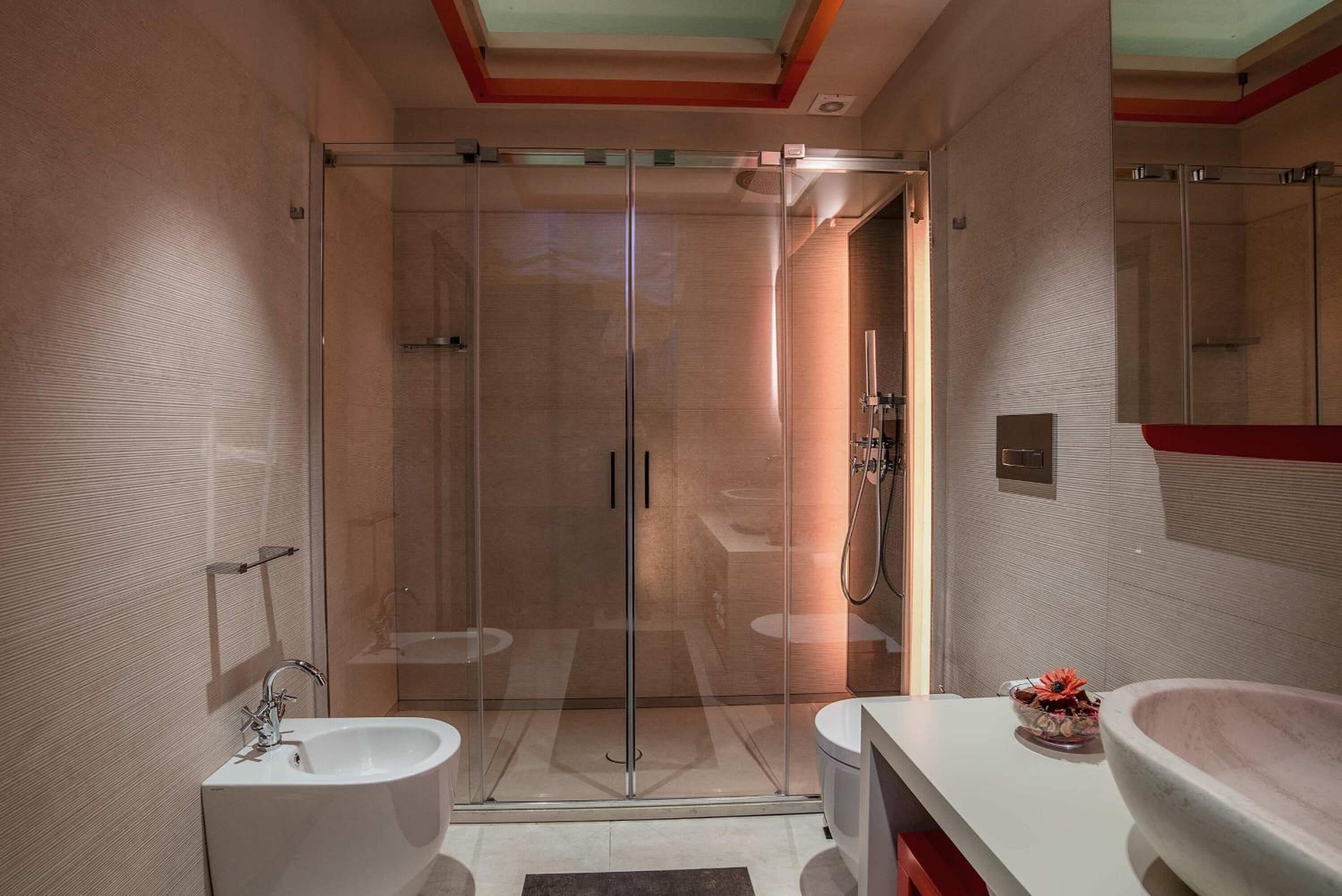 A modern bathroom with a glass-enclosed shower, a double sink vanity, and a large mirror.