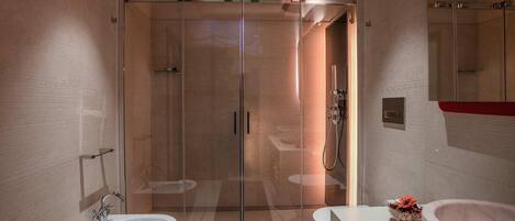 A modern bathroom with a glass-enclosed shower, a double sink vanity, and a large mirror.