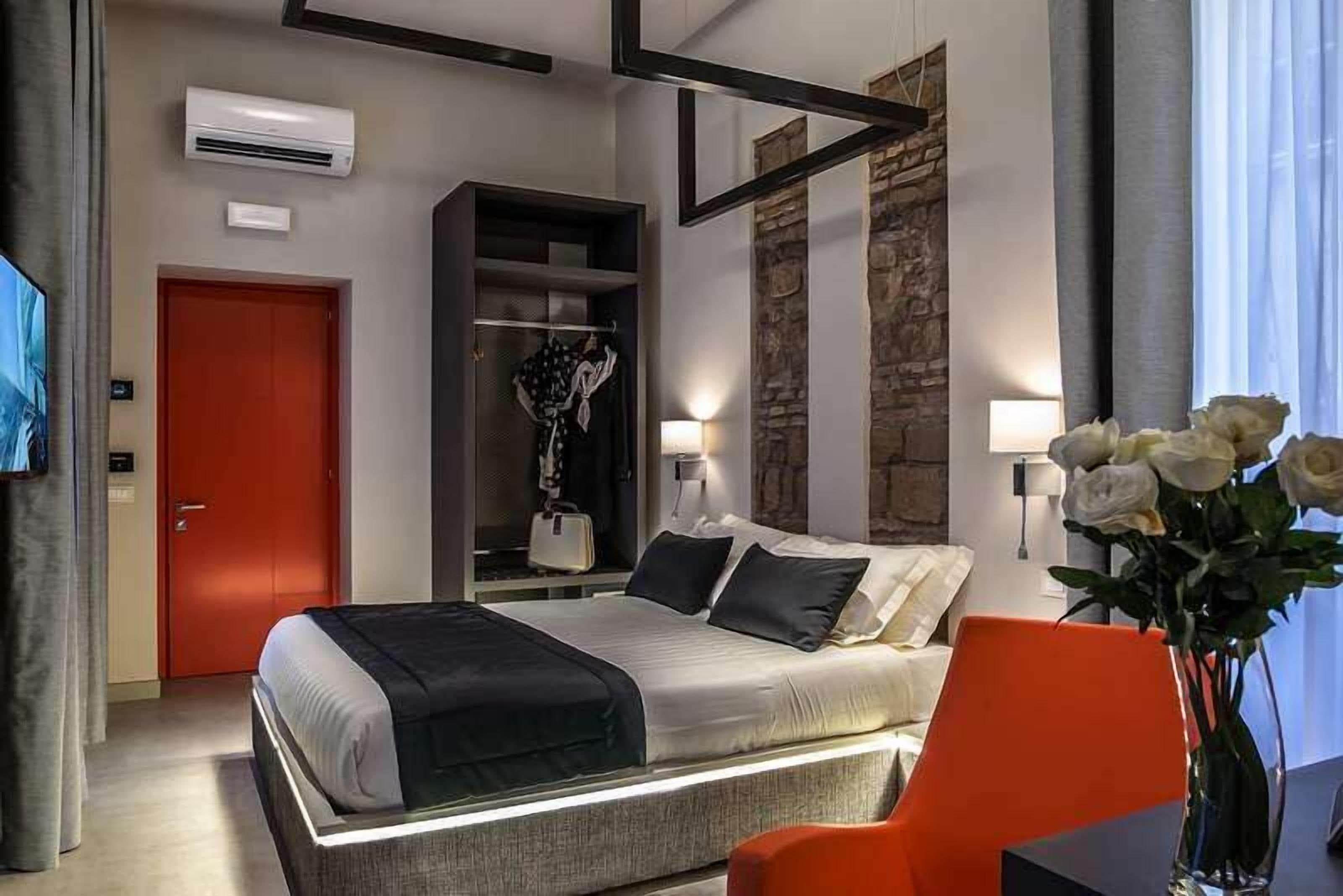Ein modernes Hotelzimmer mit Bett, Schrank, Schreibtisch und Stuhl.