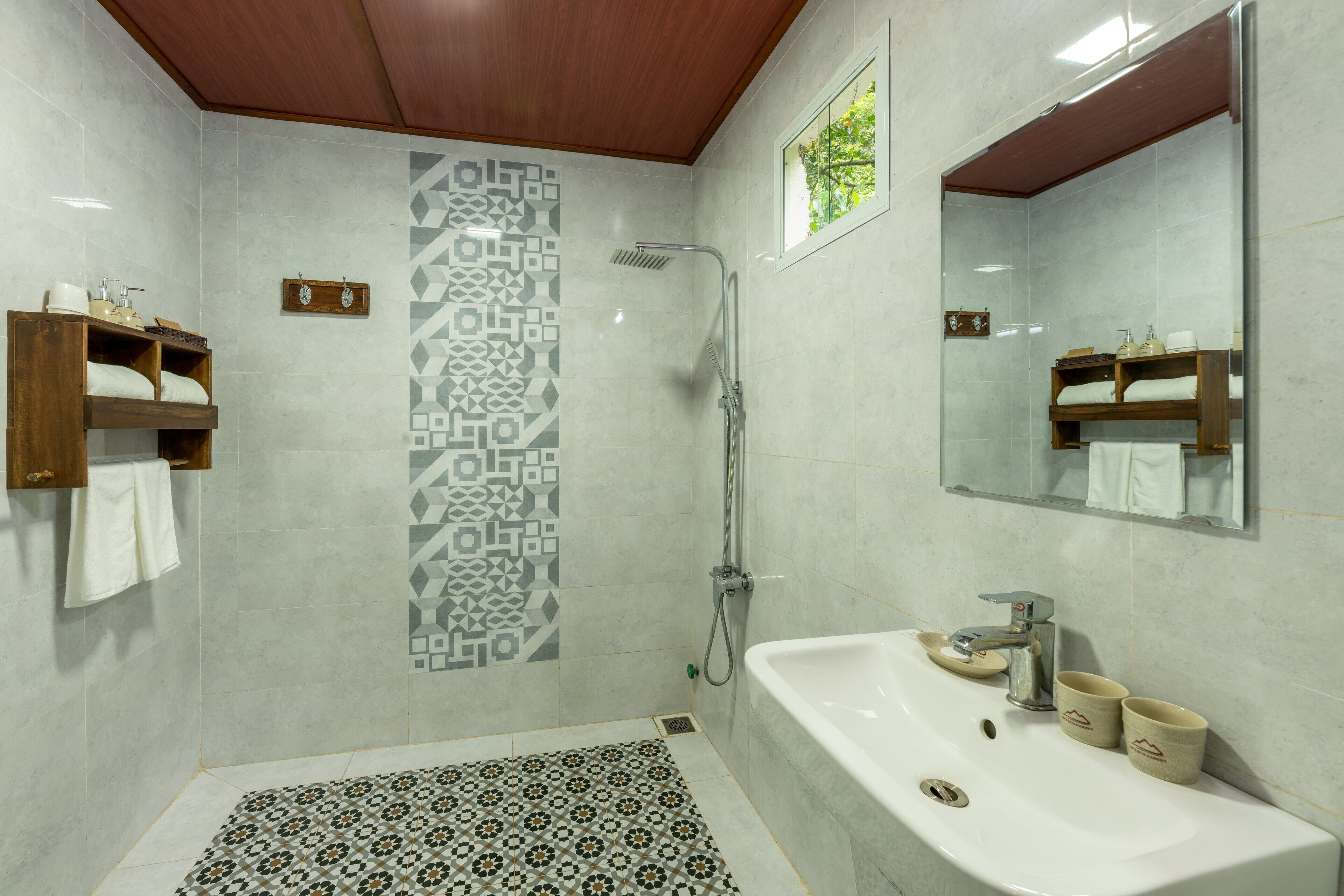 Une salle de bain moderne avec une douche, un lavabo avec deux compartiments et un miroir.