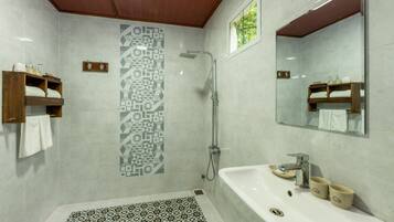 Une salle de bain moderne avec une douche, un lavabo avec deux compartiments et un miroir.