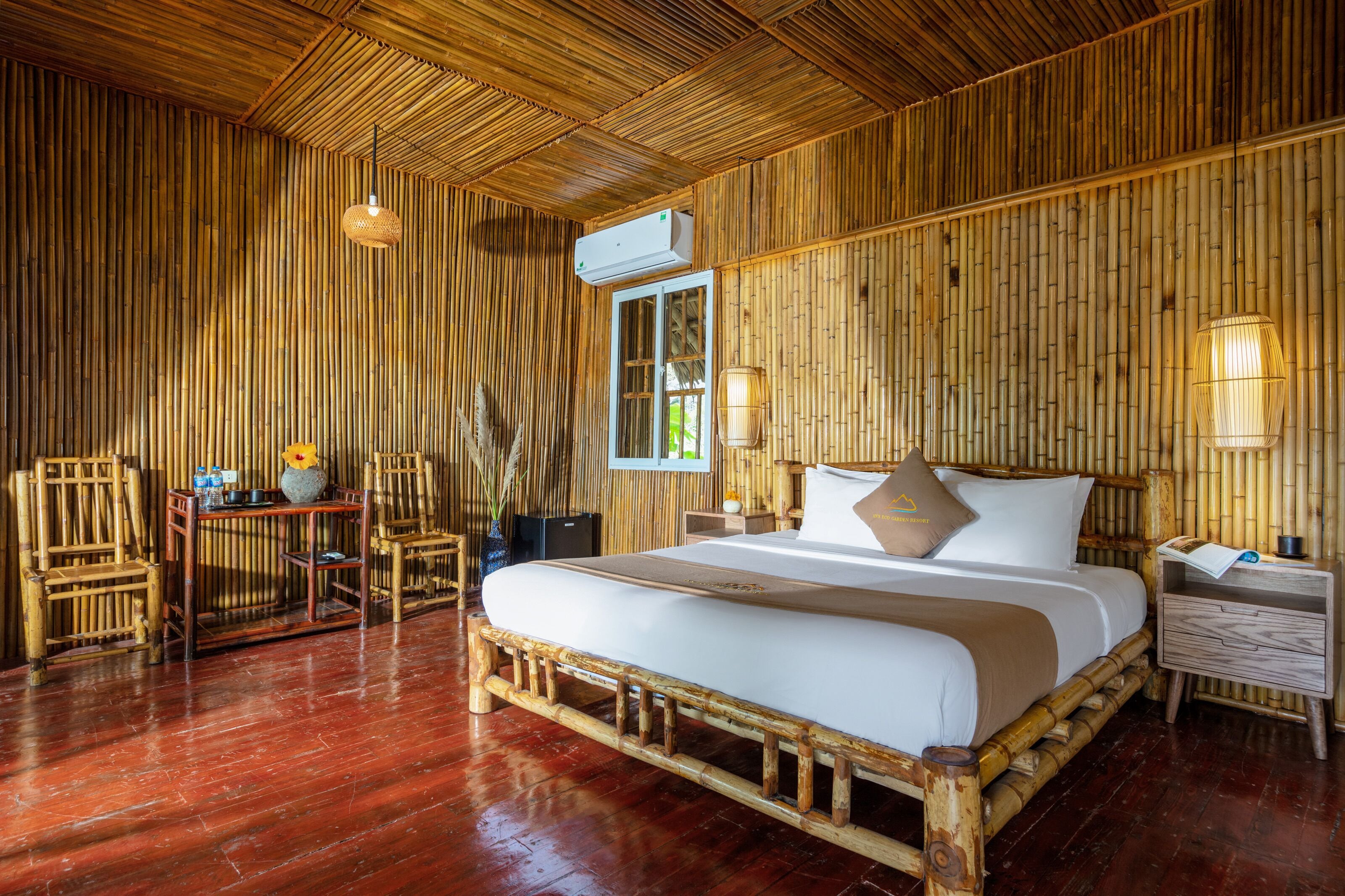 Una stanza con arredamento a tema bamboo, comprensiva di letto, comodini e una sedia.