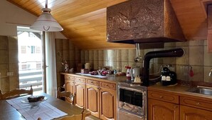 Una cocina con armarios de madera, una estufa y una mesa de comedor con sillas.