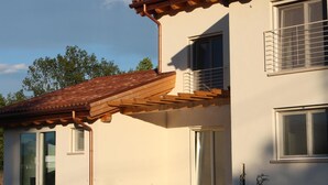 A building with a tiled roof, large windows, and a wooden pergola. - Elis' Rooms (Sernaglia della Battaglia)