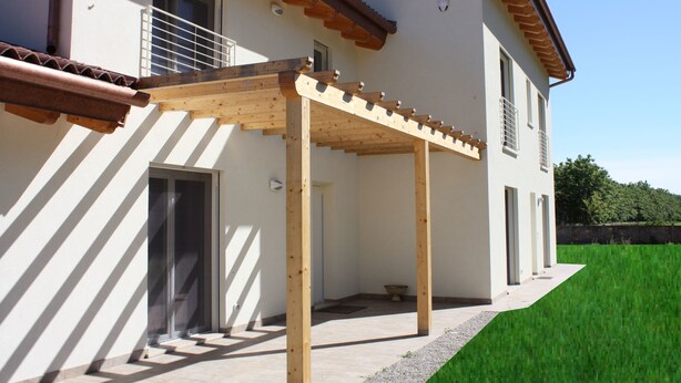 A two-story house with a covered patio area, a wooden pergola, and a well-maintained lawn. - Elis' Rooms (Sernaglia della Battaglia)