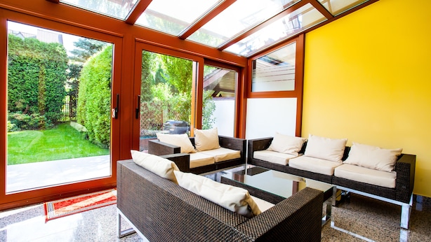 A modern living room with a glass door leading to a garden, a sofa set, and a coffee table. - Apartamenty SaltApart (Wieliczka)