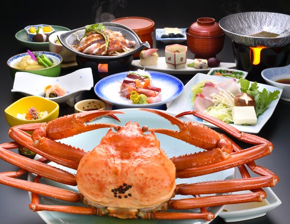 A table set with various dishes, including seafood and vegetables, and a large crab in the center. - Hotel Ogawa (Asahi)