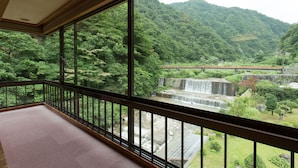 A room with a view of a waterfall and forested hills. - Hotel Ogawa (Asahi)