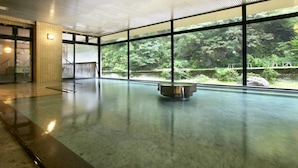 A spacious indoor area with large windows offering a view of a lush forest. - Hotel Ogawa (Asahi)