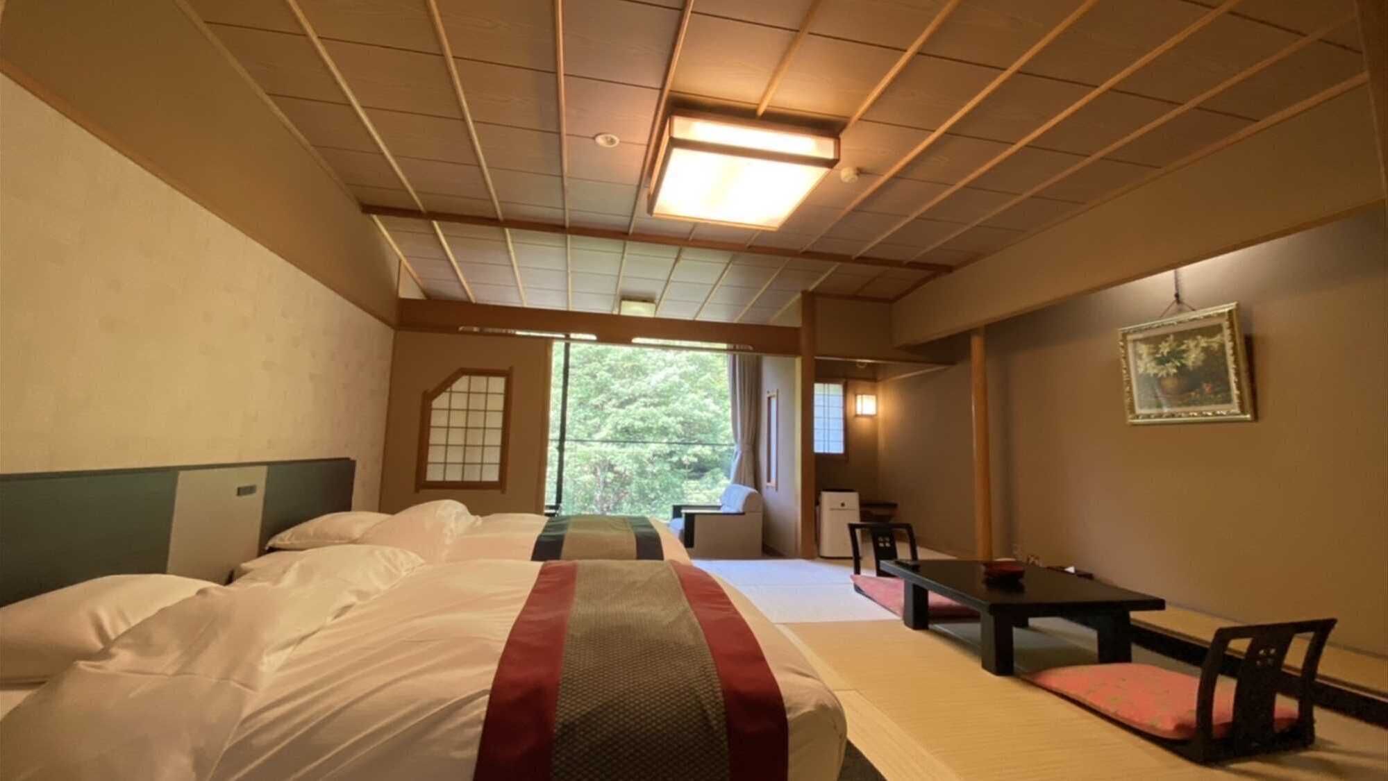 Ett hotellrum med en stor säng, ett skrivbord, en stol och ett fönster med utsikt över träd.