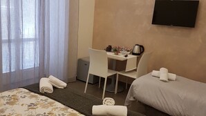 A hotel room with a bed, a desk, a chair, a TV, and a window with curtains. - Casa Aristide (Sant'Agnello)