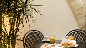 Una mesa redonda con sillas, una planta en maceta y un menú.