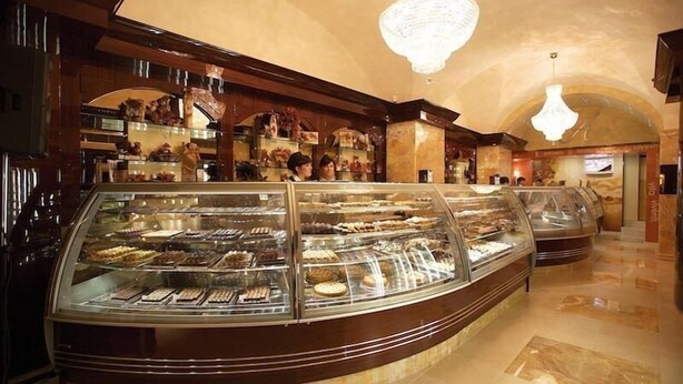 Mostrador de pastelería con diversas opciones de panadería en un ambiente hotelero.