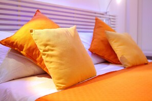 A bed with orange bedding and pillows. - MaLù Bed & Breakfast (Sorrento)