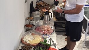 A buffet setup with various food items including meats, cheeses, fruits, and vegetables. - Alkyonides Hotel (Rhodes)