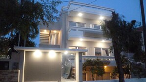 A modern hotel with a glass facade, a visible entrance, and a well-lit exterior. - Alkyonides Hotel (Rhodes)