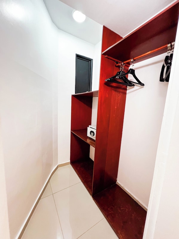 Un pasillo con un armario rojo, una puerta blanca y un electrodoméstico blanco en el suelo.
