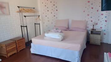 A neatly arranged bedroom with a bed, bedside tables, and a wardrobe.