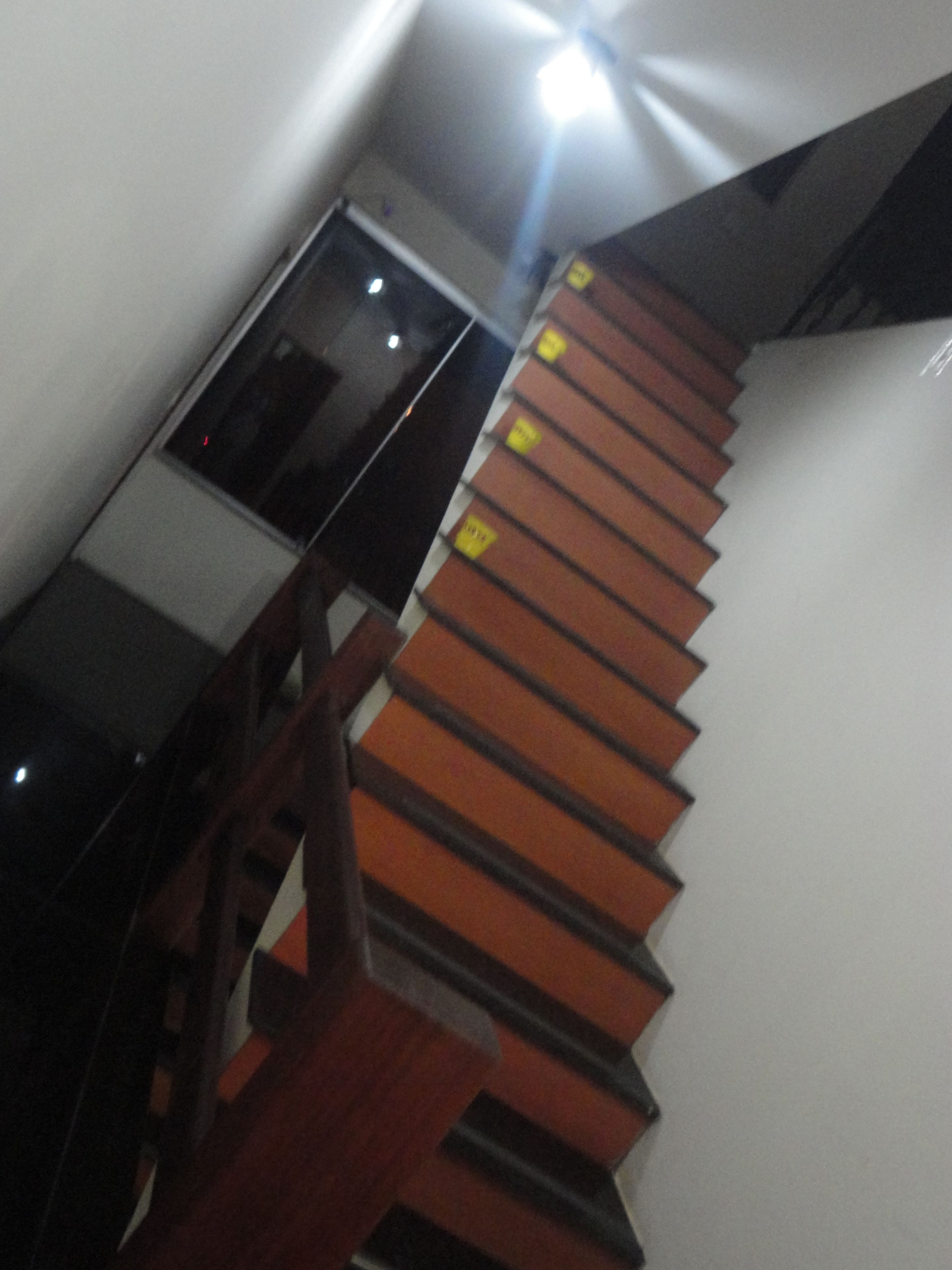 A wooden staircase with a handrail and a door at the top.
