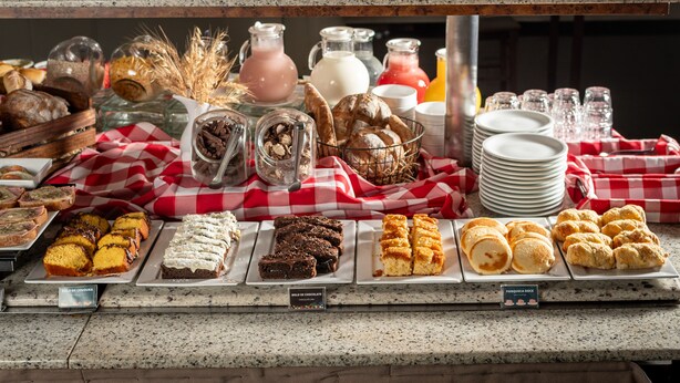 A buffet with various baked goods and beverages. - Brivali Hotel e Eventos (Cacador)
