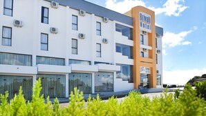 A modern hotel building with multiple air conditioning units, large windows, and a prominent sign for Brivali Hotel. - Brivali Hotel e Eventos (Cacador)
