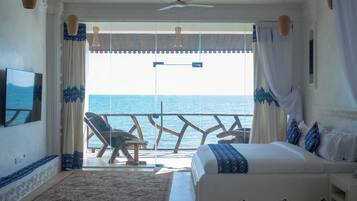 Una camera da letto con un letto grande, una TV e vista sul mare.