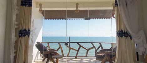 Un balcon donnant sur la mer, aménagé avec des chaises et une table.