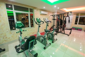 Ein Fitnessraum mit Ergometer, Kraftmaschine und Klimmzugstange.