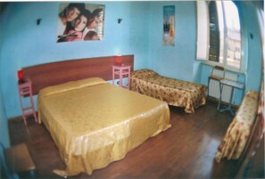A room with a large bed, a smaller bed, a nightstand, a table, and a poster on the wall. - Magic Place Guest House (Rome)