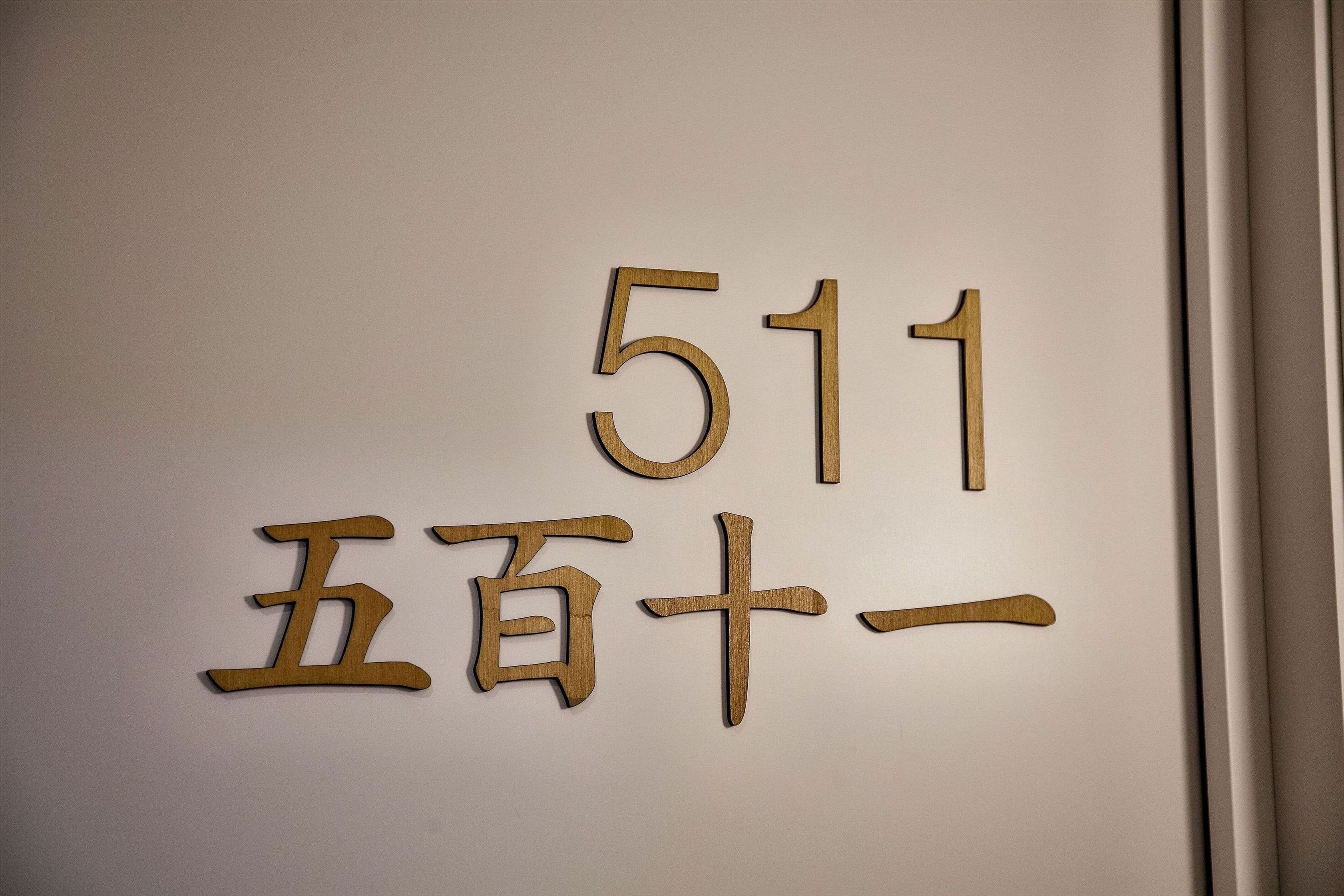 Una pared con números de madera y caracteres chinos que indican el número 511.