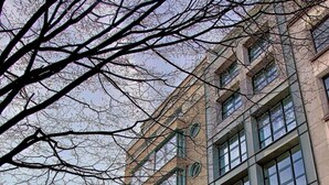 Un immeuble à étages doté d’une architecture moderne, caractérisé par de grandes fenêtres et une entrée imposante.