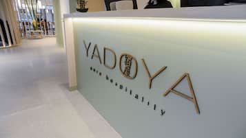Una mesa de recepción con la leyenda 'YADOYA' y 'Hospitalidad de hotel'.