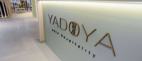 Una mesa de recepción con la leyenda 'YADOYA' y 'Hospitalidad de hotel'.