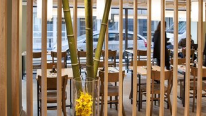 Un restaurant avec des cloisons en bois, des tables rondes et des chaises.
