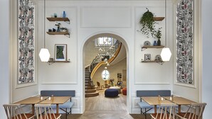 Un hall espacioso con suelo de madera, una escalera y zonas de estar.