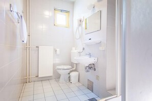 Economy tweepersoonskamer | Badkamer | Een douche, gratis toiletartikelen, een haardroger, handdoeken