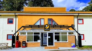 A building with a yellow facade, a black awning, and a sign that reads "Primelodge." - Primelodge Doncaster (Doncaster)
