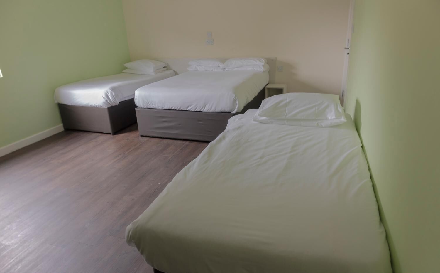 Una habitación con dos camas individuales y un pequeño sofá.