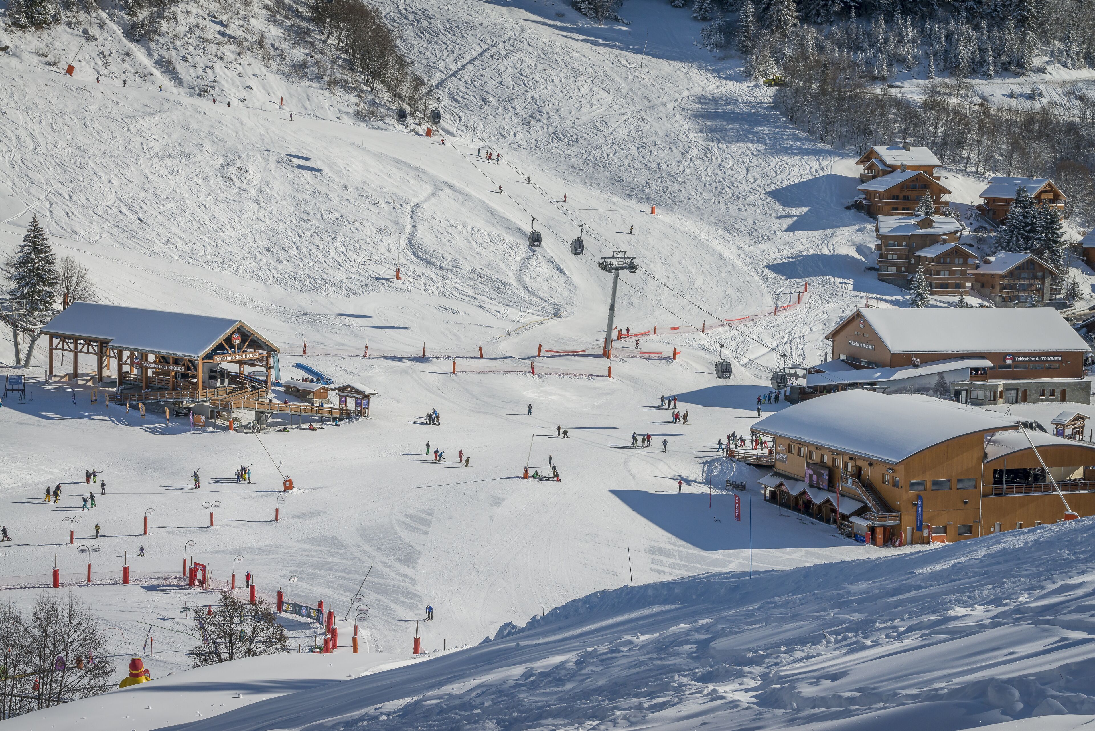 A ski resort with multiple lodges, a ski lift, and a snow-covered slope.