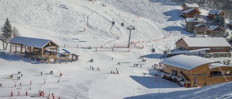 A ski resort with multiple lodges, a ski lift, and a snow-covered slope.