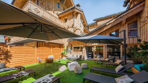 Una cabaña de madera con asientos exteriores y un patio.