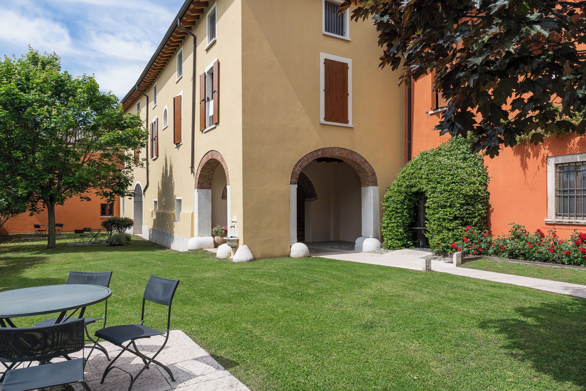 A building with a courtyard, outdoor seating, and a well-maintained lawn.