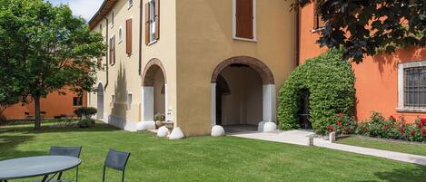 A building with a courtyard, outdoor seating, and a well-maintained lawn.