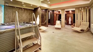 A modern spa with a hot tub, wooden loungers, and a glass-enclosed shower area. - Hotel Loft 1898 (Suwalki)