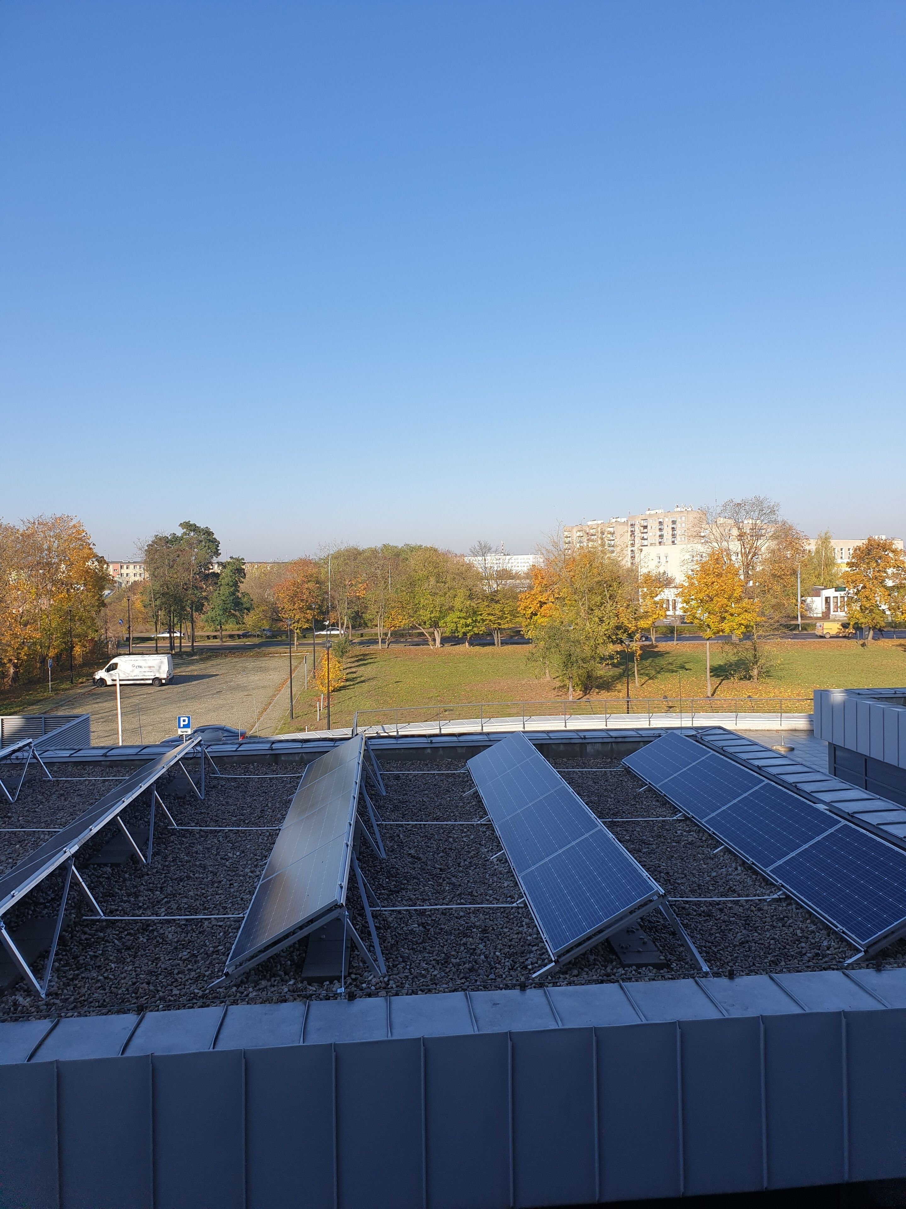Un toit équipé de panneaux solaires et un panneau indiquant les places de stationnement.