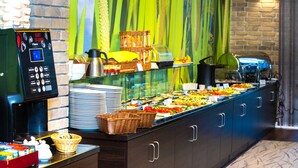 A buffet with various food items, a coffee machine, and baskets. - Hotel Loft 1898 (Suwalki)