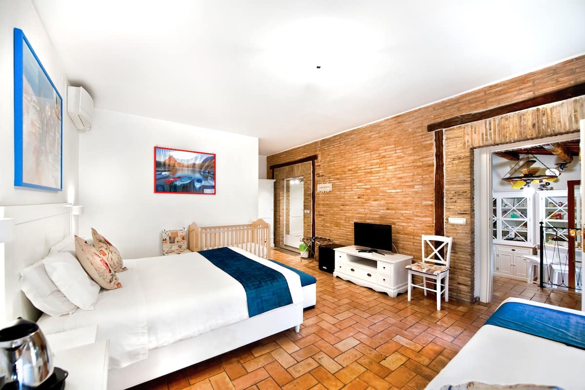 A modern bedroom with a large bed, a TV, and a small desk.