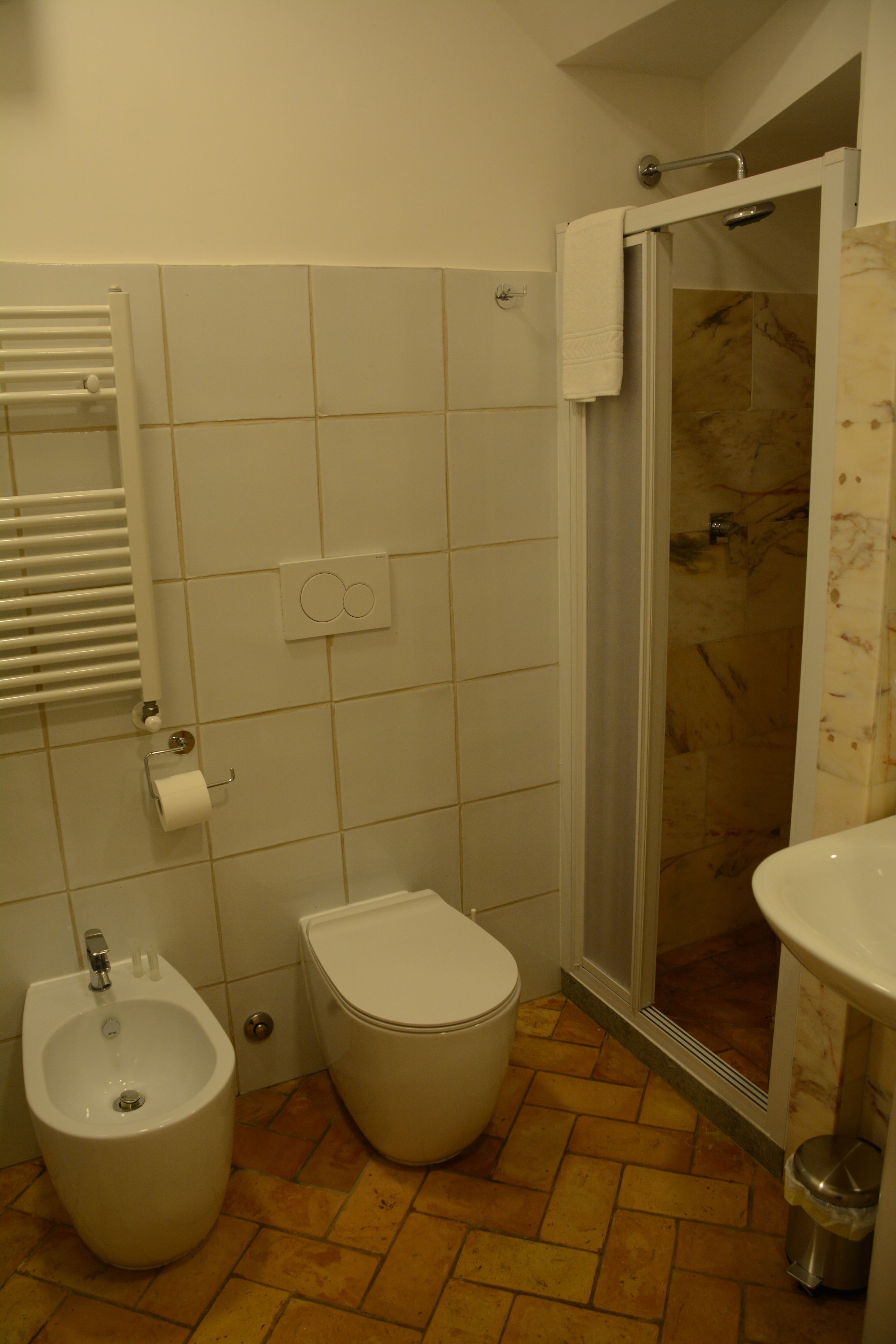 Une salle de bain équipée d’un bidet, de toilettes, d’une douche et d’un lavabo.