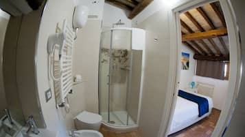 Een kleine badkamer met douche, toilet en wastafel.