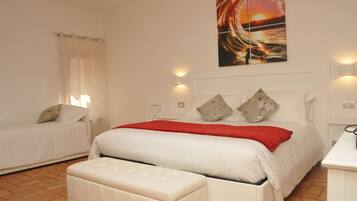 A bedroom with a bed, a bench, a nightstand, and a wall-mounted painting.